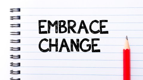 Embrace Change Text written on notebook page, red pencil on the right. Motivational Concept image